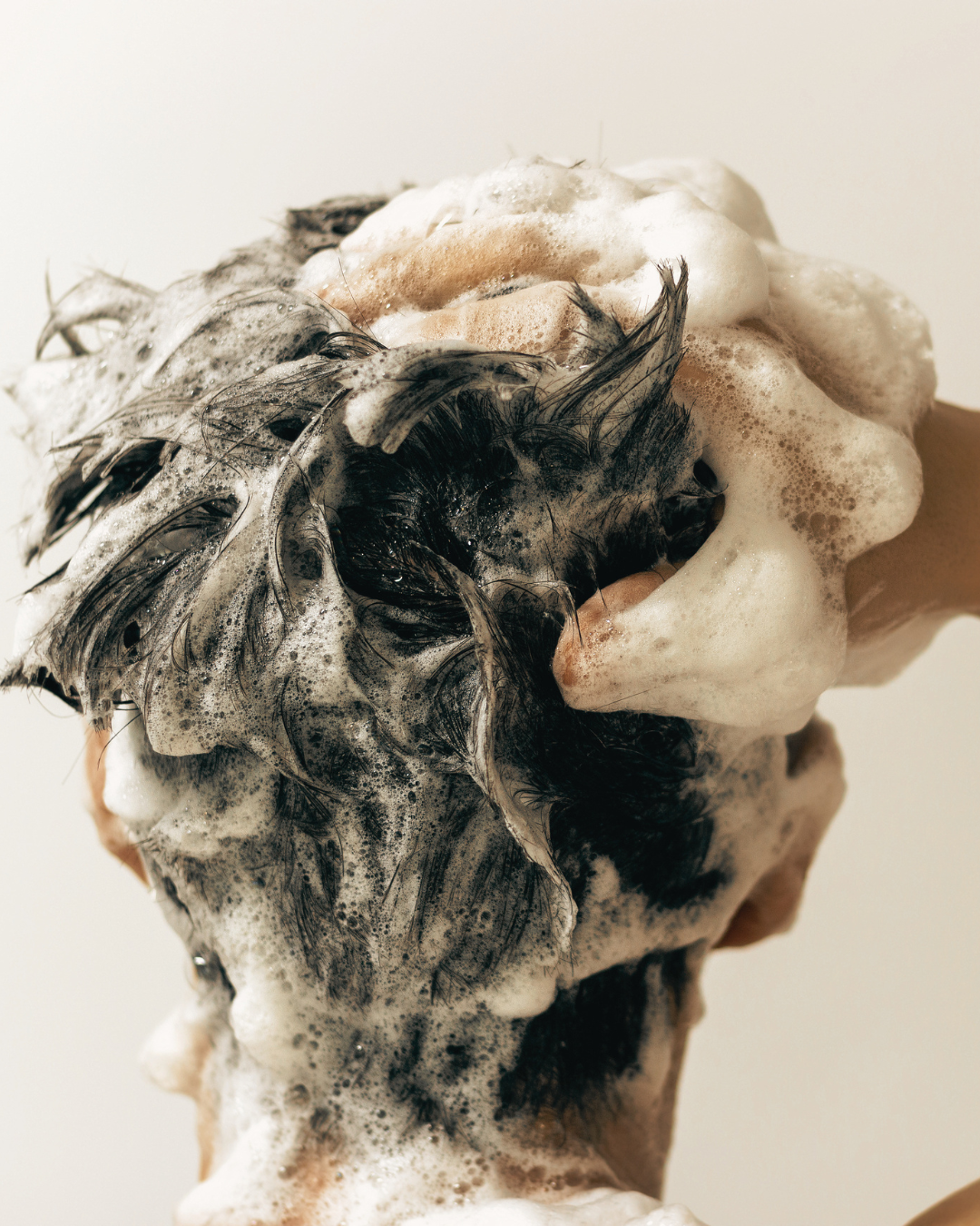 Man washing hair in the shower using premium shampoo