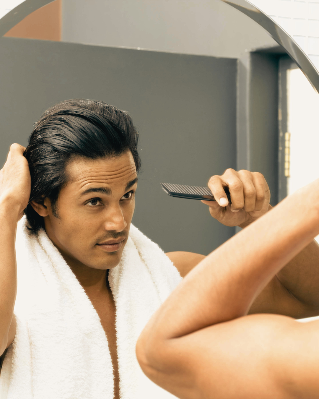 Barber using a hairdryer and brush to style a man's hair
