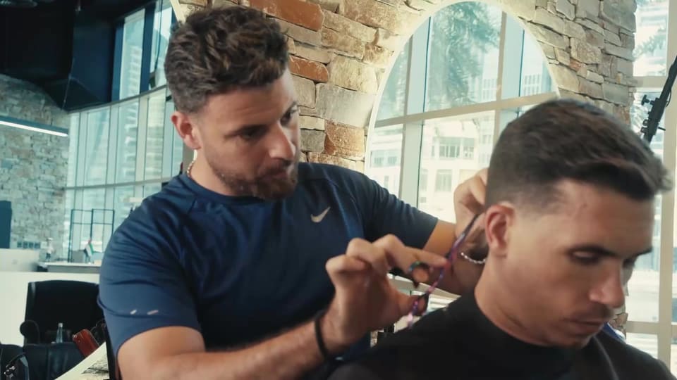 Barber doing a scissor cut at Casa Barbershop