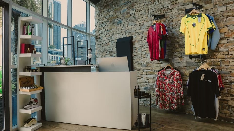 Front desk at Casa with grooming products and shirts on the stone wall